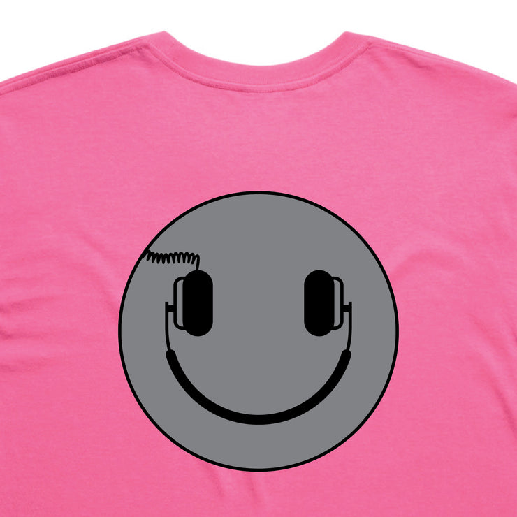 Pink t-shirt with a gray smiley face design featuring headphones on a white background