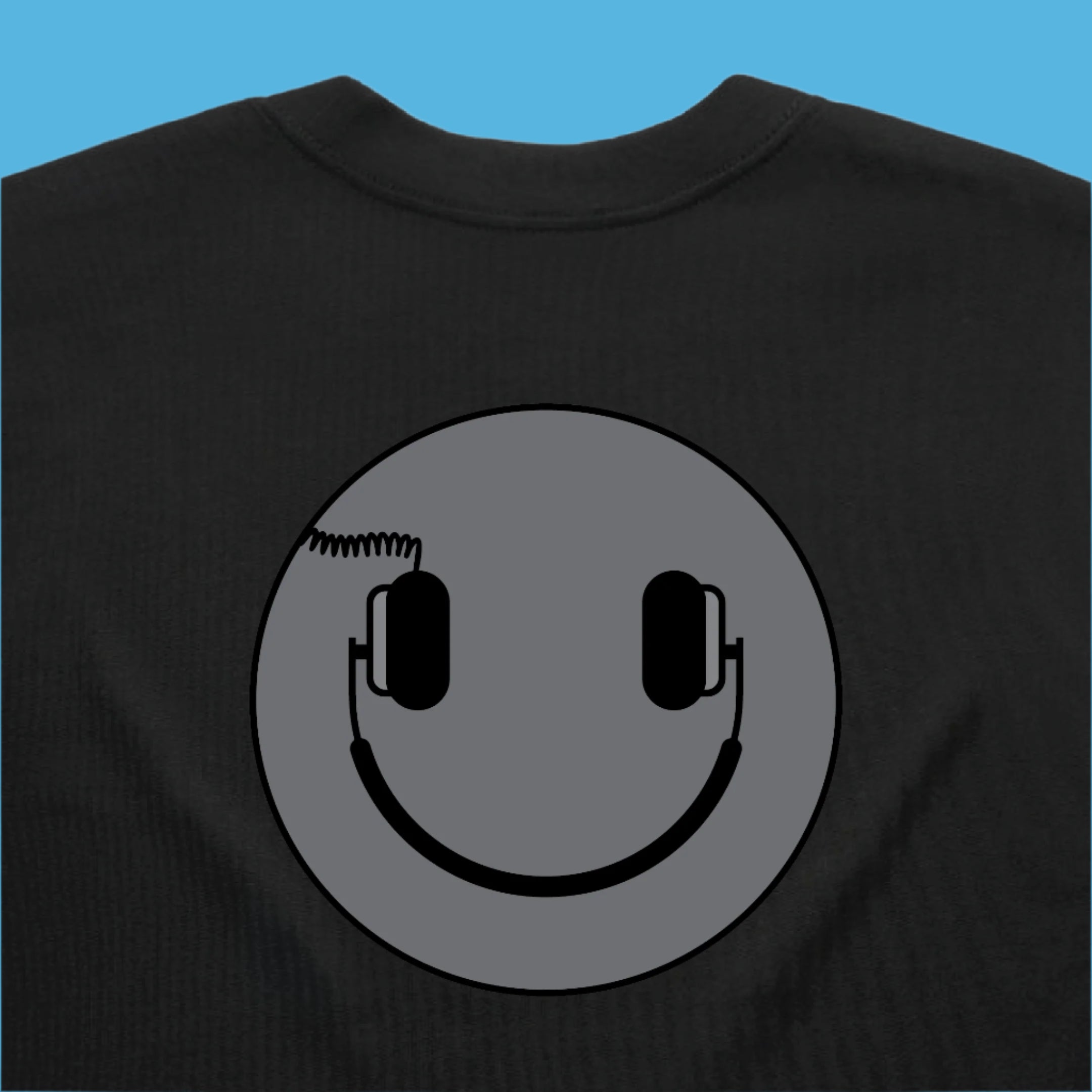 Black sweatshirt with a smiley face design featuring headphones on a gray background.